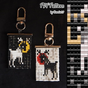 Peut inclure: Deux porte-clés perlés avec fermoirs en métal. L'un présente un fond noir avec un motif de chèvre blanche et de lune jaune. L'autre a un fond blanc avec une chèvre noire et des accents rouges. Le texte "PDF Pattern by Carola17" est en haut.