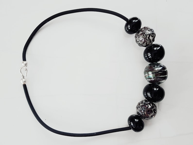 May include: A black necklace with a silver clasp and black and silver beads.