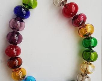May include: A rainbow colored glass bead necklace with a copper wire strung through the beads.