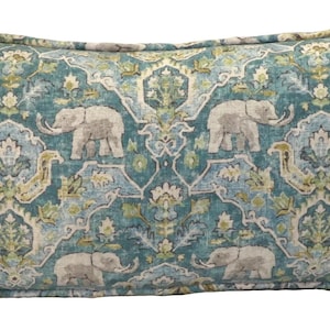 May include: A teal blue throw pillow with a repeating pattern of stylized elephants and floral designs in shades of green, yellow, and white.