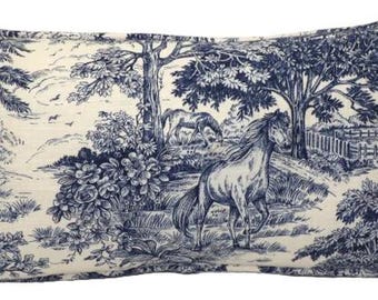 May include: A white and blue rectangular pillow with a toile pattern featuring horses and trees. The pillow has a blue and white trim.