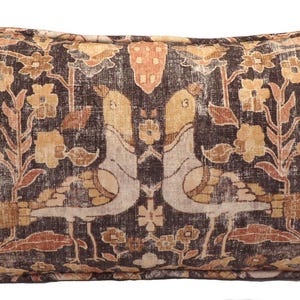 May include: A rectangular pillow with a brown background and a floral pattern in shades of beige, orange, and brown. The pattern features stylized birds and floral motifs.