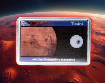 May include: A display case featuring a Martian Shergottite meteorite. The case shows a portion of Mars, a small white rock, and the word "Tissint" in white text. The background shows a red planet.