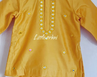 Puede incluir: Una kurta amarilla con bordado de espejo y pantalones blancos. La kurta tiene un cuello mandarín y mangas largas. Los pantalones son blancos lisos.