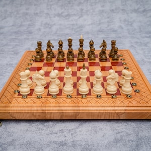 Ręcznie robiona szachownica z czerwonej żywicy epoksydowej z nogami z brązu i drewnianymi figurami