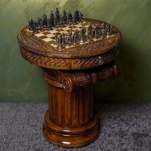May include: A wooden chess table with a carved design and a chessboard with black and white squares. The chess pieces are made of metal and are arranged in a starting position.