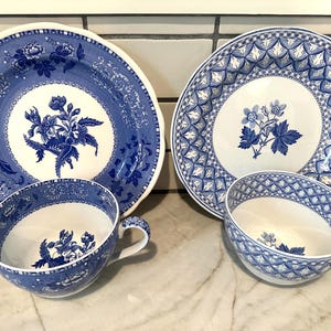 May include: A set of blue and white porcelain dishes, including two plates and two teacups. The plates feature floral and geometric patterns. The teacups have matching designs. The set is ideal for serving tea or displaying as decorative items.