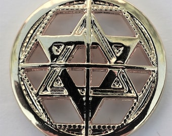 May include: Gold-toned metal button with a geometric design featuring a six-pointed star in the center.