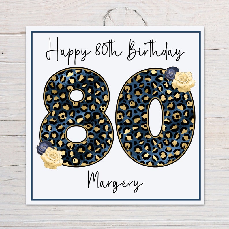 Puede incluir: Una tarjeta blanca con el texto "Happy 80th Birthday" y el n&uacute;mero 80 en estampado de leopardo azul y dorado. El nombre "Margery" est&aacute; escrito debajo del n&uacute;mero 80.
