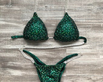 May include: A green and silver sequined bikini with a halter top and a high-cut bottom.