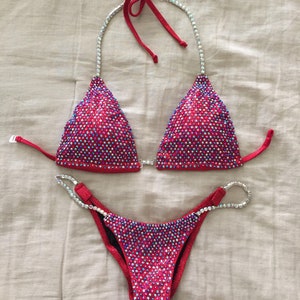 May include: A red and silver sequined bikini with a halter top and a high-cut bottom.