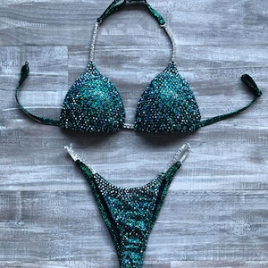 May include: A green and silver sequined bikini with a halter top and a high-cut bottom.