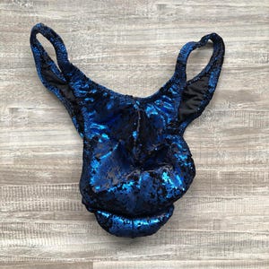 May include: Blue sequined swimsuit with a low-cut back and thin straps.