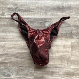 May include: Red and black metallic swimsuit with a low-cut front and a high-cut back.