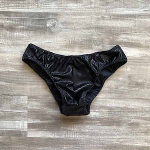 May include: Black underwear with a shiny, textured fabric.