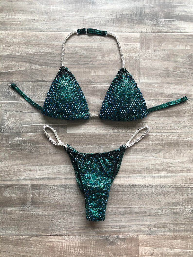 May include: A green and silver sequined bikini with a halter top and a high-cut bottom.
