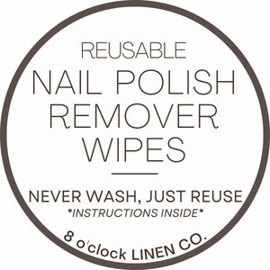 May include: Circular label with the text "REUSABLE NAIL POLISH REMOVER WIPES" in a dark brown font. The text "NEVER WASH, JUST REUSE" is below the main text, with "*INSTRUCTIONS INSIDE*" underneath. The brand name "8 o'clock LINEN CO." is at the bottom.