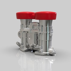 May include: A silver dual carburetor with two red air filters. The carburetor has a silver finish and is designed for a high-performance engine.