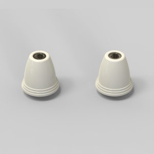 Puede incluir: Dos terminales de l&aacute;mpara de cer&aacute;mica blanca con un agujero roscado en la parte superior. Los terminales tienen una parte superior redondeada y una base ligeramente acampanada.