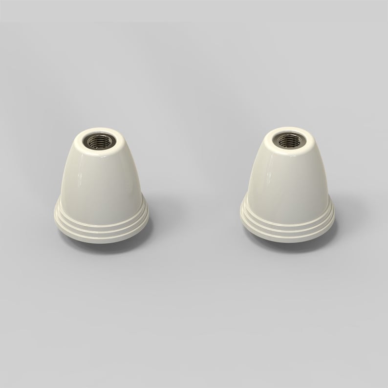 Puede incluir: Dos terminales de l&aacute;mpara de cer&aacute;mica blanca con un agujero roscado en la parte superior. Los terminales tienen una parte superior redondeada y una base ligeramente acampanada.