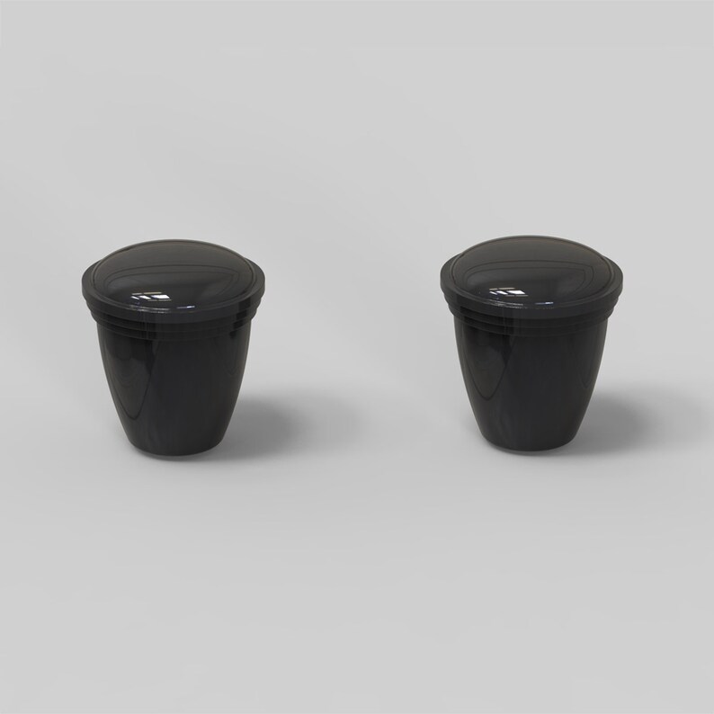 Puede incluir: Dos recipientes de pl&aacute;stico negro con tapas. Los recipientes son redondos y tienen un acabado liso y brillante.