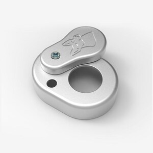 Puede incluir: Una pipa de metal de color plateado con una tapa con bisagras. La tapa tiene un pequeño tornillo y un diseño de cabeza de perro. La pipa tiene una abertura redonda en el lateral.