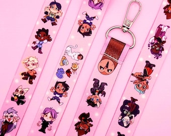 May include: Pink lanyards with cartoon character designs. The lanyards display a repeating pattern of various characters and a silver-coloured clasp. The background is a solid pink colour.