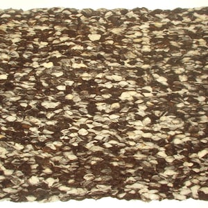 May include: A brown and white woven rug with a textured surface. The rug is made of natural fibers and has a rustic look.