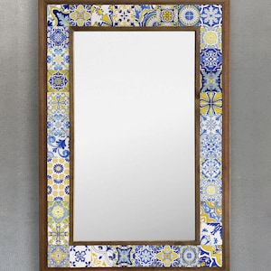 May include: Rectangular mirror with a wooden frame. The frame is decorated with a border of colorful, patterned tiles in shades of blue, yellow, and white. The mirror is a decorative home decor item.