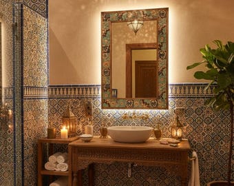 May include: A bathroom with a Moroccan theme, featuring a carved wooden vanity with a white basin, a decorative mirror, and patterned tiles. A hanging lantern and candles add to the ambiance. A potted plant and a patterned rug complete the scene.