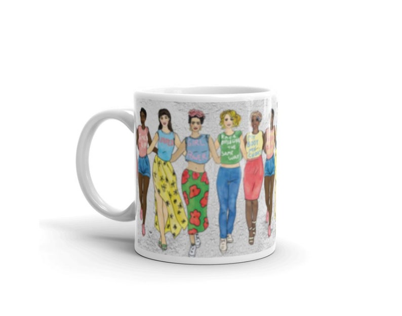 May include: White ceramic mug with a colorful illustration of a group of women standing together. The women are wearing different outfits and have different hairstyles. The text on the mug reads "I'm pretty sure we're all in the same gang".