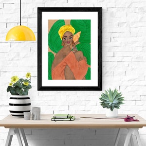 May include: A framed illustration of a woman with dark skin wearing a yellow turban and a peach-colored dress. She is holding a seashell to her ear and is surrounded by green leaves.