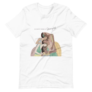 May include: White t-shirt with a graphic of five women of different skin tones standing in a circle with their arms around each other. The text "In unity there is strength" is printed above the graphic.