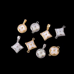 May include: Eight pendant charms in various shapes, including circles and diamonds, with a four-petal flower design. The charms are gold and silver-toned, with a mother-of-pearl inlay and a small central bead.
