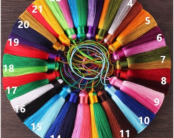 May include: A set of 22 colourful silk tassels numbered 1 to 22. The tassels are arranged in a circle on a wooden surface.