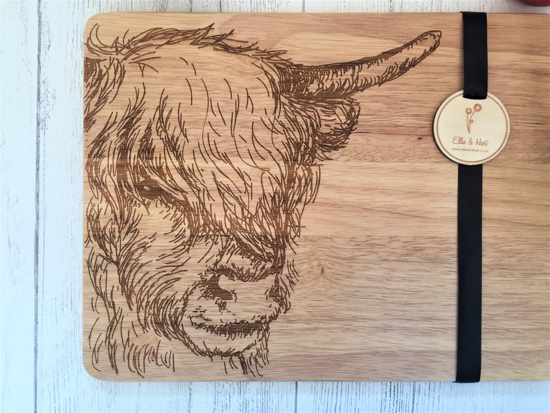 a wooden cutting board with a picture of a cow on it