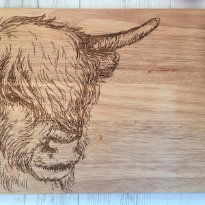 a wooden cutting board with a picture of a cow on it