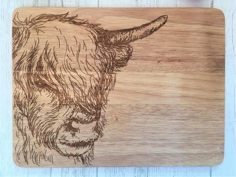 a wooden cutting board with a picture of a cow on it