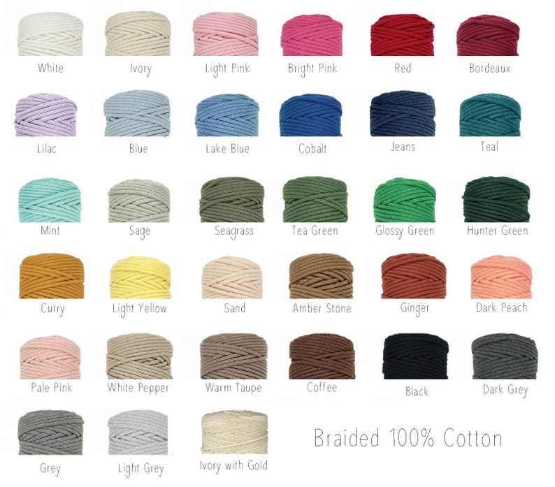 Op de afbeelding: Een collectie van eenendertig klossen gevlochten 100% katoenen koord gerangschikt in een raster, elk gelabeld met de specifieke kleurnaam, waaronder wit, ivoor, roze, rood, blauw, groen, geel, bruin, grijs en zwart.