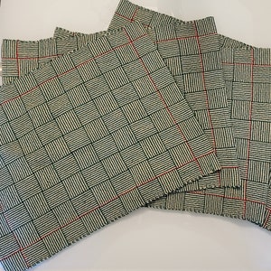 May include: Set of six green and white woven placemats with red trim. The placemats have a checkered pattern.