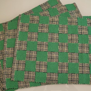 Könnte beinhalten: Vier gewebte Tischsets in grün und beige mit Karomuster.