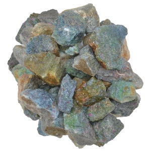 May include: A pile of rough, green, blue, and brown gemstones. The stones are irregularly shaped and have a sparkly, iridescent finish.