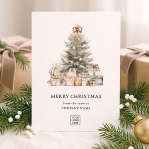 Op de afbeelding: Een kerstkaart met een aquarel illustratie van een versierde kerstboom en ingepakte cadeaus. De kaart leest "MERRY CHRISTMAS" en bevat ruimte voor een bedrijfslogo en -naam. Groene dennentakken en gouden ornamenten omlijsten de kaart.