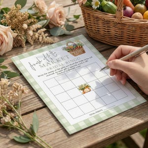 May include: A bridal bingo game card with a green gingham pattern and the text "Fresh off the Market". The card includes a basket illustration and instructions. A hand is holding a pen, ready to play.