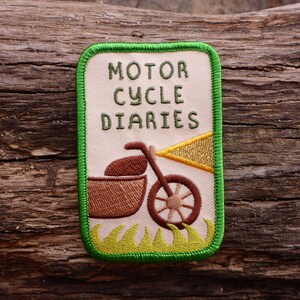 May include: Green embroidered patch with a white background. The patch features a motorcycle with a sidecar and the text "MOTOR CYCLE DIARIES".