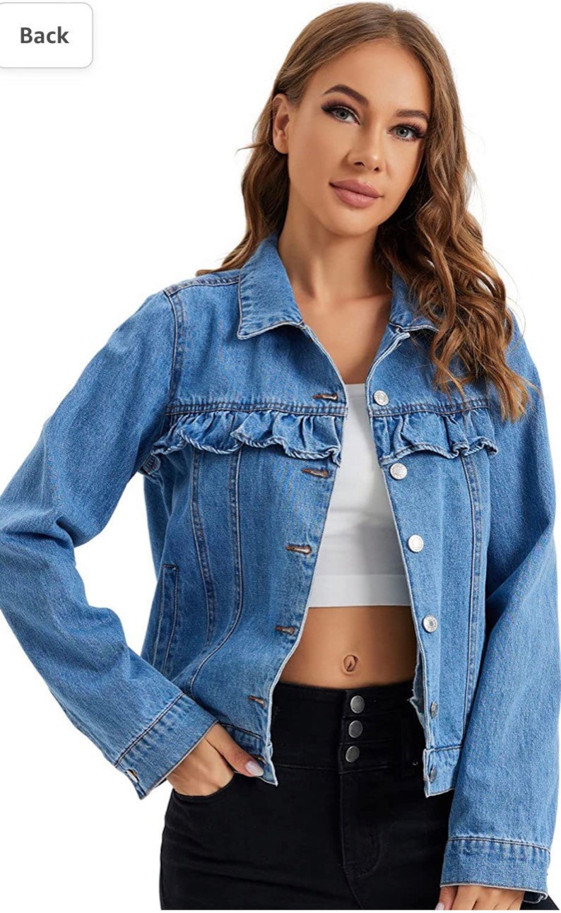 K&ouml;nnte beinhalten: Eine hellblaue Jeansjacke mit R&uuml;schenbesatz an der Brust. Die Jacke hat einen Knopfverschluss und lange &Auml;rmel.