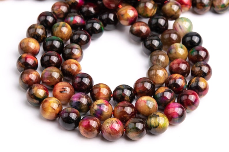 May include: A strand of round, multi-colored tiger's eye beads. The beads are a mix of gold, brown, red, and black with iridescent shimmer.
