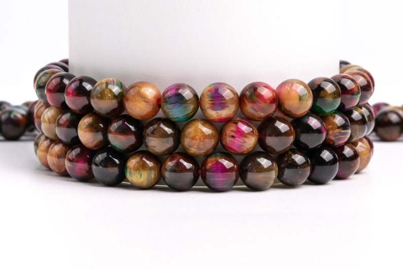 May include: A strand of iridescent tiger's eye beads in shades of brown, gold, and red. The beads are round and have a smooth, polished finish.