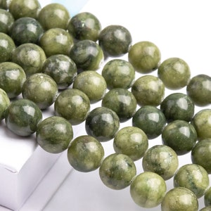 Pu&ograve; includere: Una collana di perle di giada verde e bianca. Le perle sono rotonde e lisce, e hanno un aspetto naturale e organico.