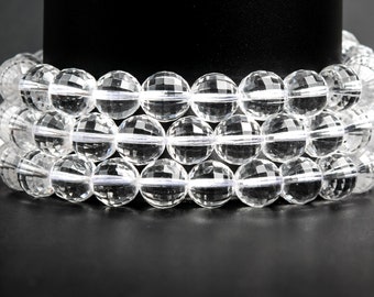 May include: Three clear quartz crystal bead bracelets. Each bracelet is composed of faceted, round beads. The beads are strung together, creating a layered effect. The bracelets are displayed against a black background.